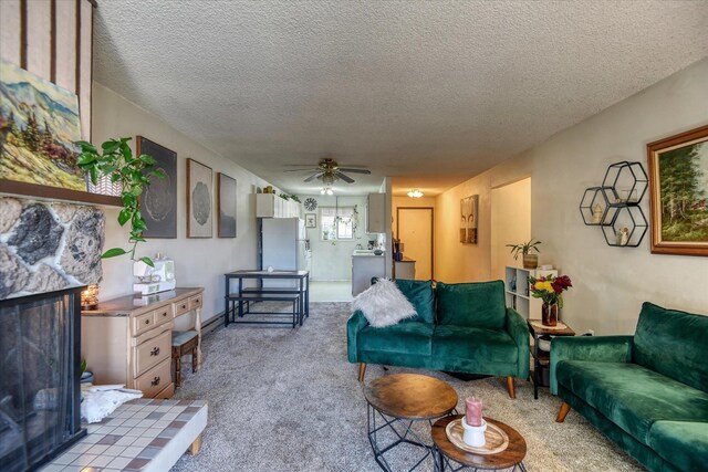 2121 E Upriver Dr # 19, Spokane, WA 99207 - living room with carpet flooring, a ceiling fan, a textured ceiling, and a stone fireplace