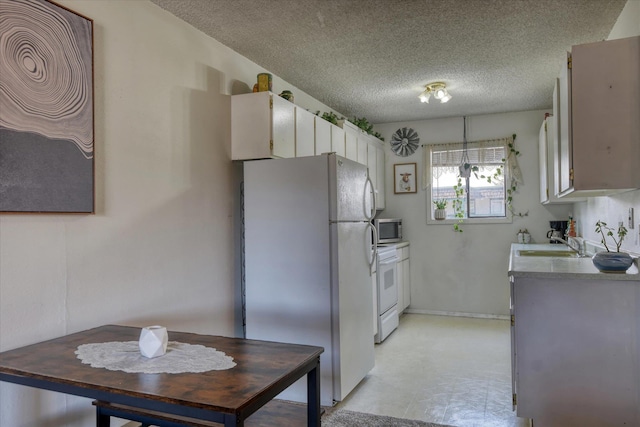 2121 E Upriver Dr # 19, Spokane, WA 99207 - kitchen with white appliances, a textured ceiling, a sink, and light floors