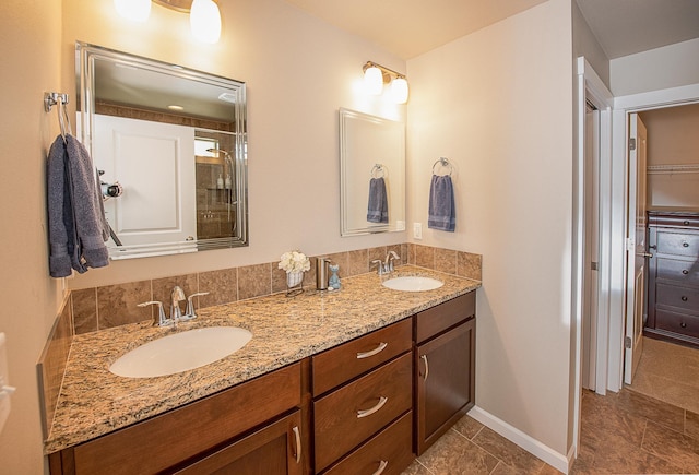 full bath with double vanity, baseboards, and a sink