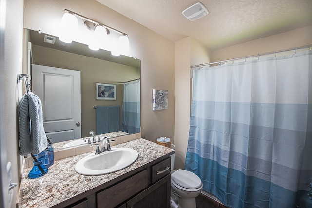 bathroom featuring visible vents, a textured ceiling, toilet, and vanity