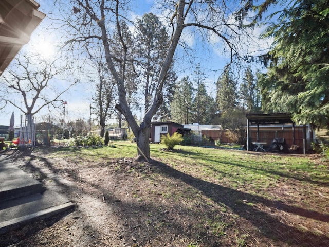 view of yard with fence and an outbuilding