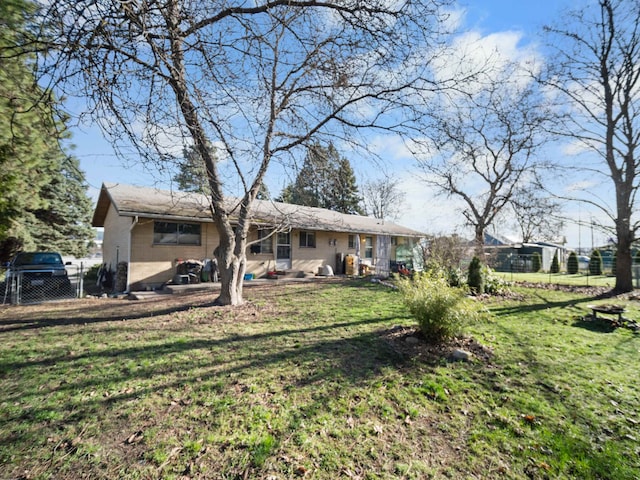 rear view of house with a yard and fence