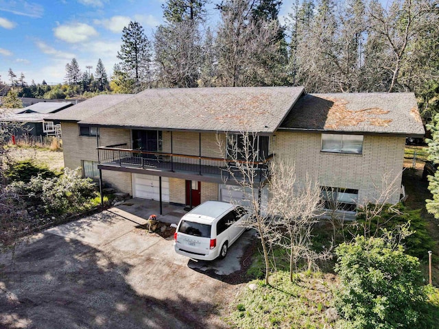 view of front facade featuring an attached garage, aphalt driveway, and brick siding