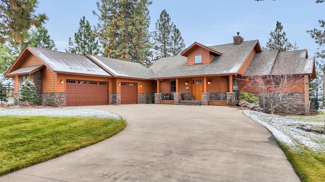 view of front facade featuring a garage, a front lawn, stone siding, a chimney, and concrete driveway