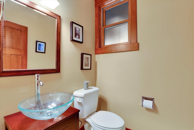 half bathroom featuring vanity and toilet