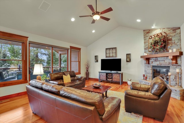 living room with visible vents, a fireplace, baseboards, light wood-type flooring, and a ceiling fan