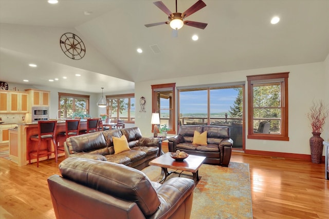 living room featuring recessed lighting, ceiling fan, high vaulted ceiling, and light wood-style floors