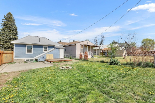 rear view of house with a yard, a patio, a wooden deck, and a fenced backyard
