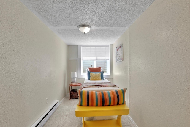 bedroom featuring a baseboard radiator, a textured wall, carpet flooring, and a textured ceiling