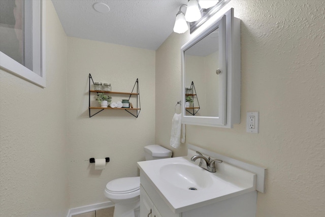 half bath with vanity, tile patterned floors, and toilet