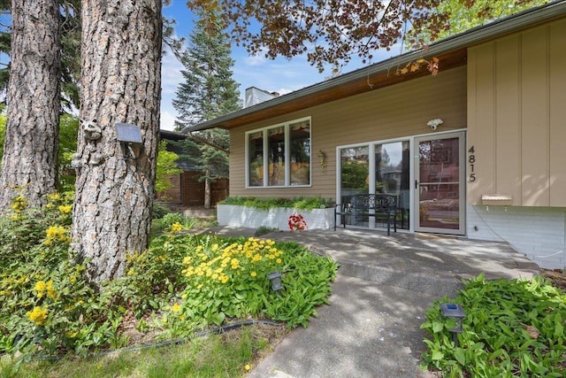 entrance to property with board and batten siding and a chimney