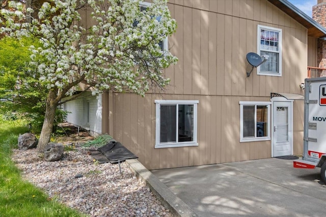 view of side of home with a chimney and a patio area