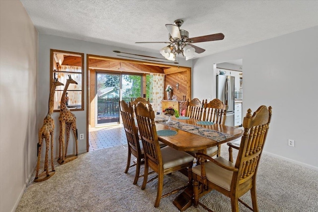 dining room featuring carpet floors, a ceiling fan, a textured ceiling, and baseboards