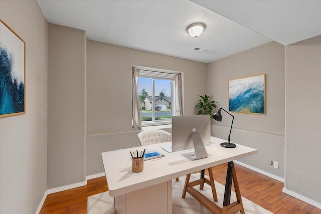 office space with visible vents, baseboards, and wood finished floors