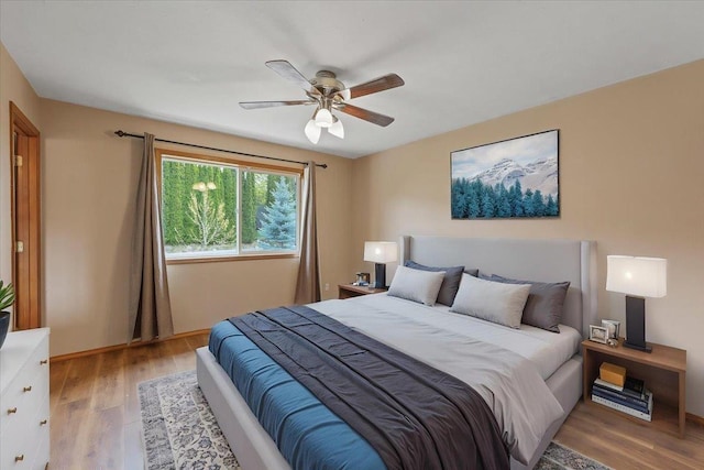 bedroom with baseboards, a ceiling fan, and wood finished floors