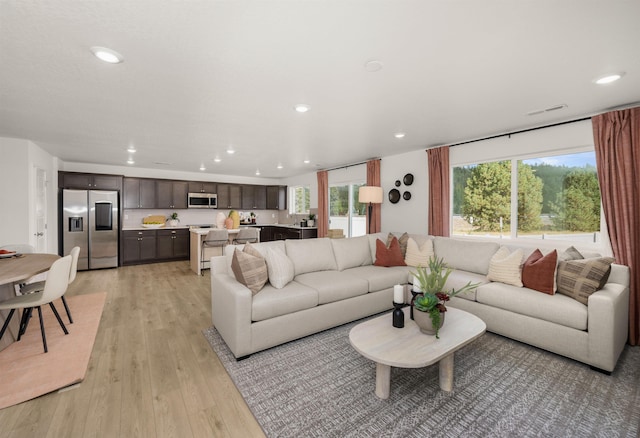 living room featuring recessed lighting, a wealth of natural light, and light wood-type flooring