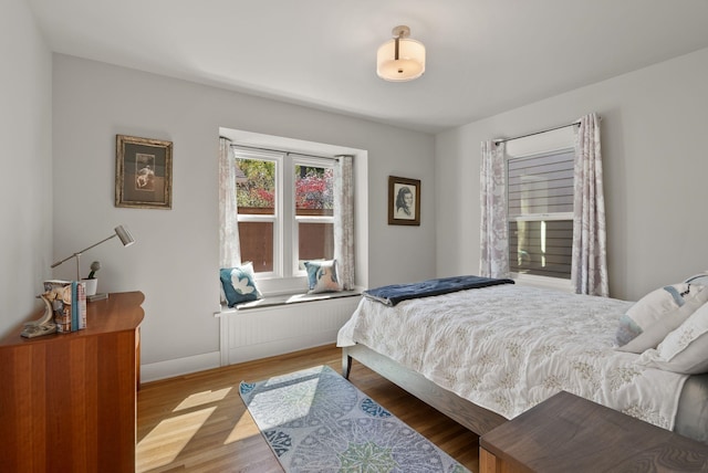 bedroom with baseboards and wood finished floors