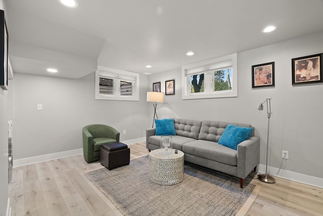living room with recessed lighting, baseboards, and light wood-type flooring