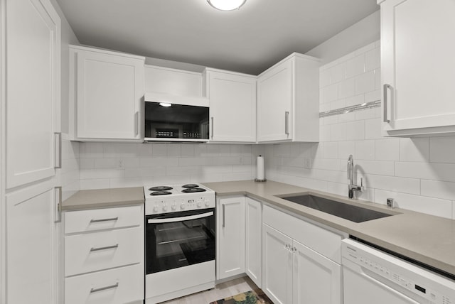 kitchen featuring a sink, white appliances, and white cabinetry
