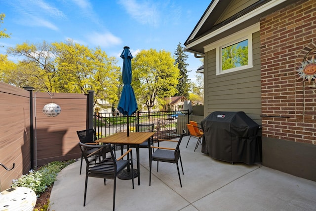 view of patio / terrace with fence, outdoor dining space, and a grill