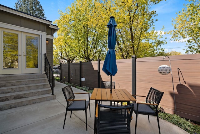 view of patio / terrace featuring fence, french doors, and outdoor dining area