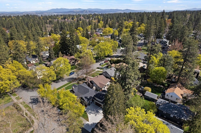 drone / aerial view with a view of trees, a mountain view, and a residential view