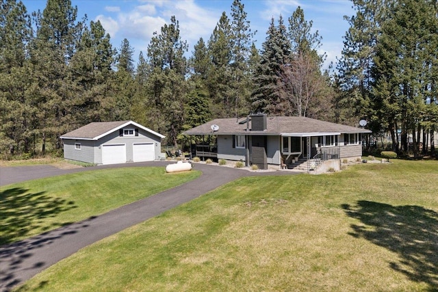 view of front of house featuring an outdoor structure, a garage, a front lawn, and a porch