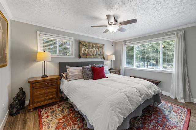 bedroom featuring baseboards, wood finished floors, and multiple windows