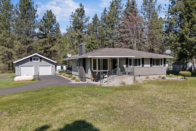 view of front facade featuring a garage, an outdoor structure, a chimney, and a front lawn