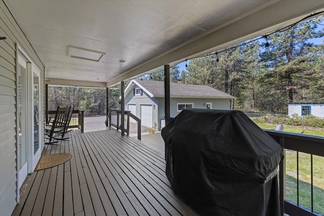 deck with area for grilling, an outbuilding, and a shed