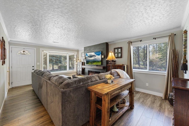 living room featuring baseboards, ornamental molding, wood finished floors, and a fireplace