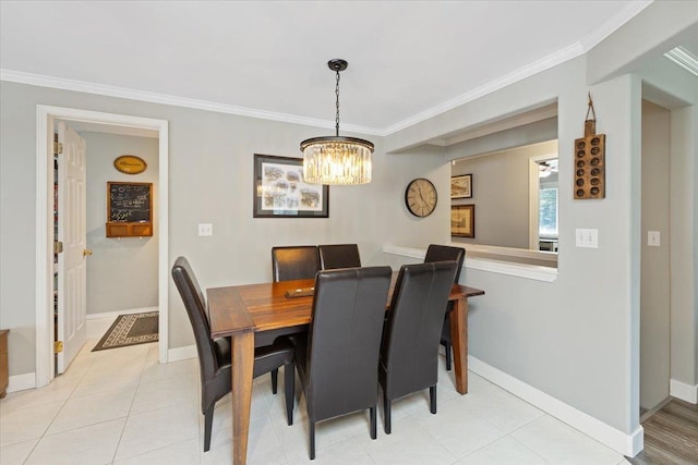 dining room featuring crown molding, baseboards, light tile patterned floors, and a notable chandelier