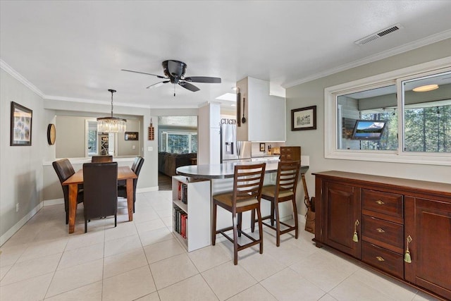 dining area featuring plenty of natural light, ornamental molding, ceiling fan with notable chandelier, and visible vents