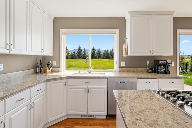 kitchen with visible vents, a sink, white cabinetry, and stainless steel appliances
