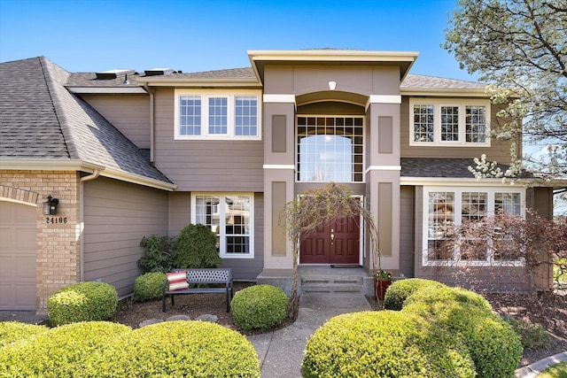 view of front of home with a shingled roof and an attached garage