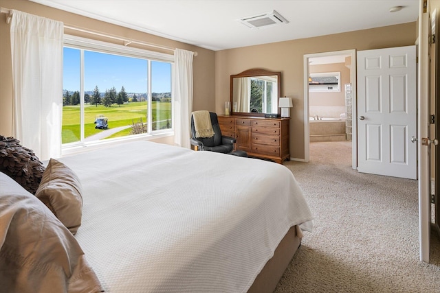 bedroom featuring visible vents, light colored carpet, ensuite bathroom, and golf course view