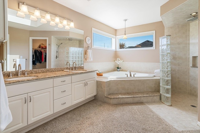 bathroom featuring a garden tub, a sink, walk in shower, and double vanity
