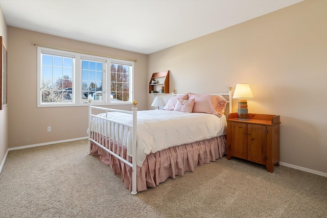 bedroom with baseboards and light colored carpet