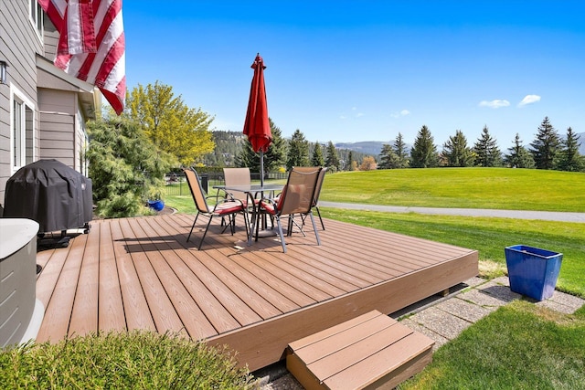 wooden terrace with a mountain view, outdoor dining area, a yard, and grilling area