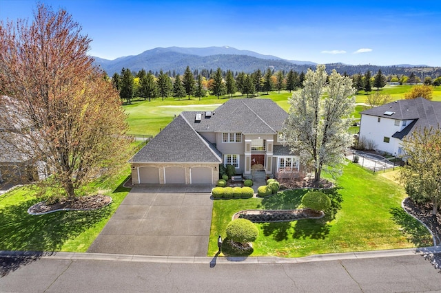 traditional-style house with a garage, fence, driveway, and a front yard