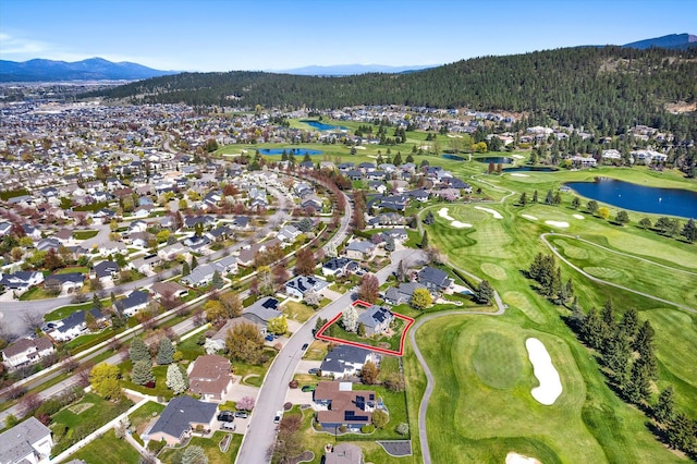 aerial view with a wooded view, view of golf course, a residential view, and a water and mountain view