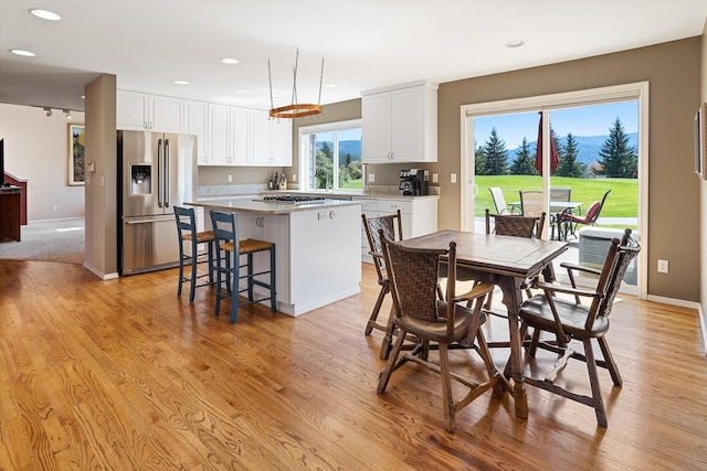 dining space with recessed lighting, light wood-style flooring, and baseboards