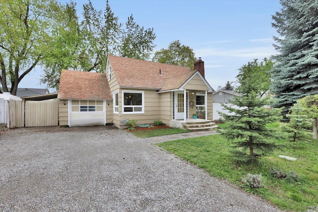 bungalow-style home with a shingled roof, fence, driveway, and a chimney