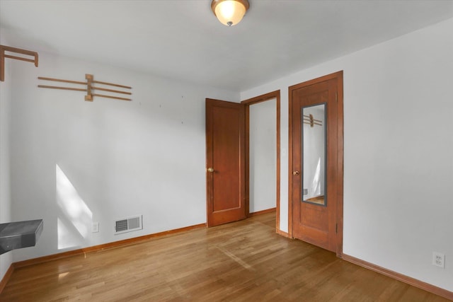 unfurnished bedroom with baseboards, visible vents, and wood finished floors