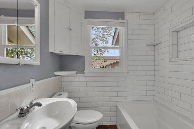 full bathroom featuring toilet, tile walls, and a sink