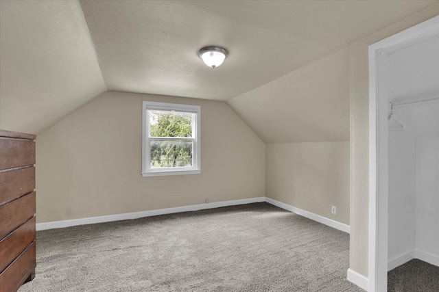 bonus room featuring baseboards, carpet, and vaulted ceiling