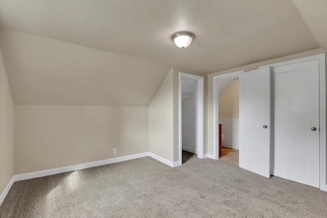 bonus room with carpet flooring, baseboards, and vaulted ceiling