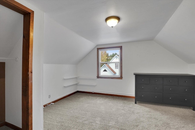 additional living space featuring baseboards, carpet, and lofted ceiling