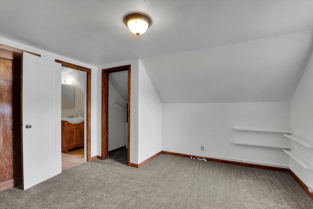 additional living space featuring baseboards, light colored carpet, and lofted ceiling