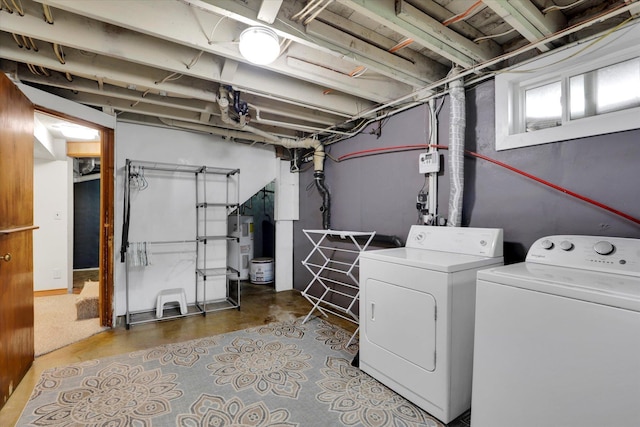 clothes washing area featuring laundry area, independent washer and dryer, and water heater
